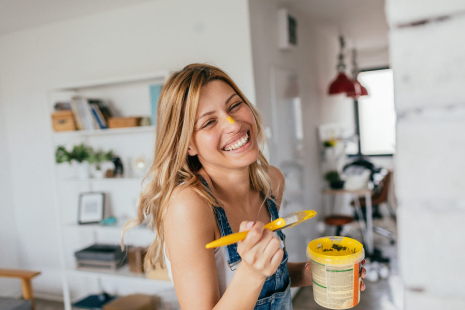 Women smiling as she paints her home